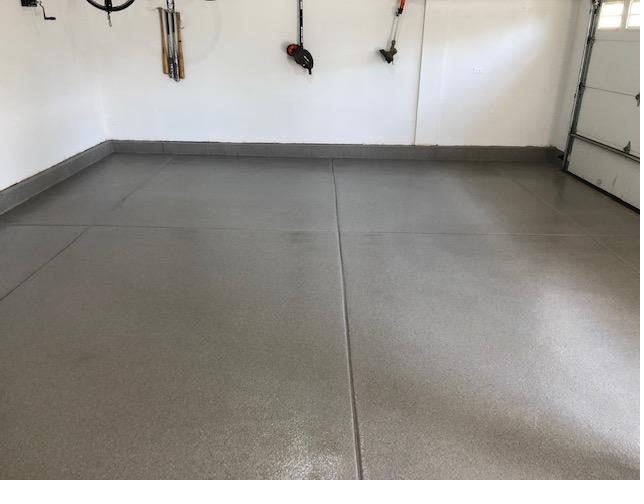 Finished gray flake epoxy garage floor with tool storage on the wall